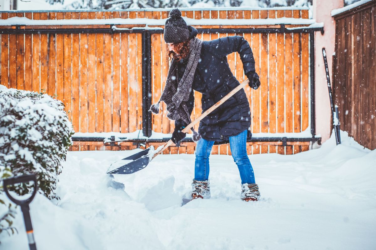 Woman shoveling snow off driveway