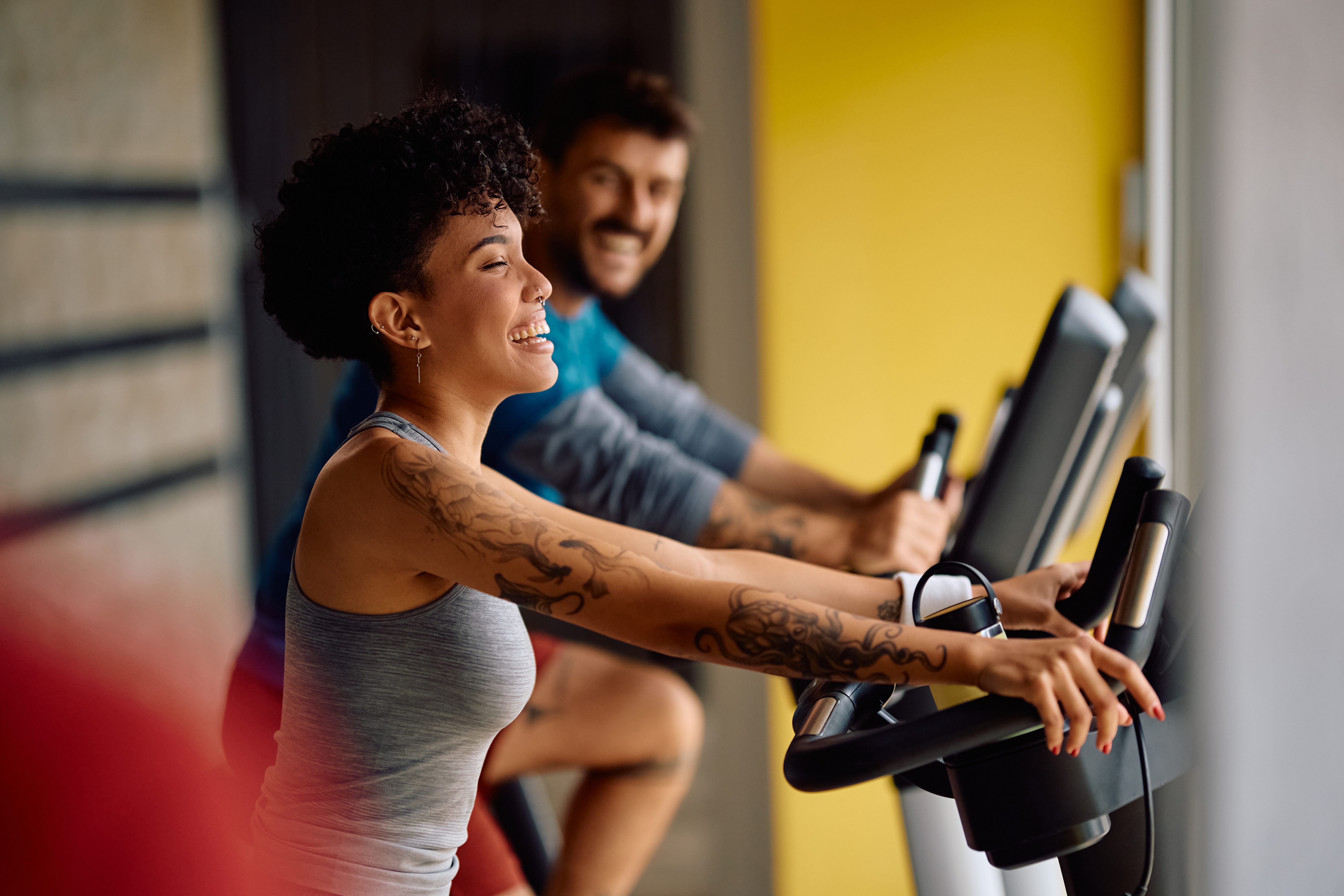 Achieve health and fitness goals, happy woman on cardio bike