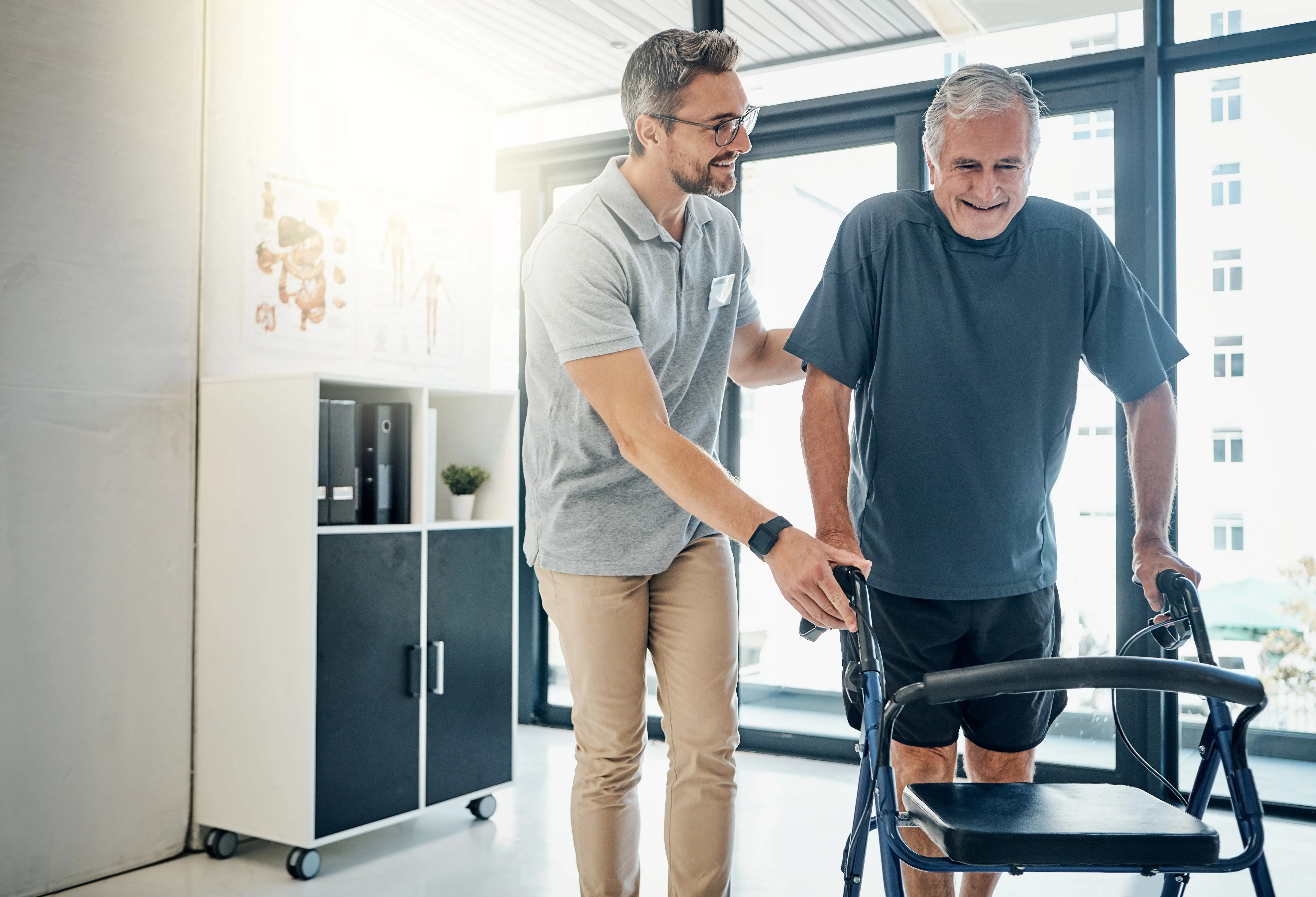 Physiotherapist supporting patient with Parkinson's disease with walking exercise